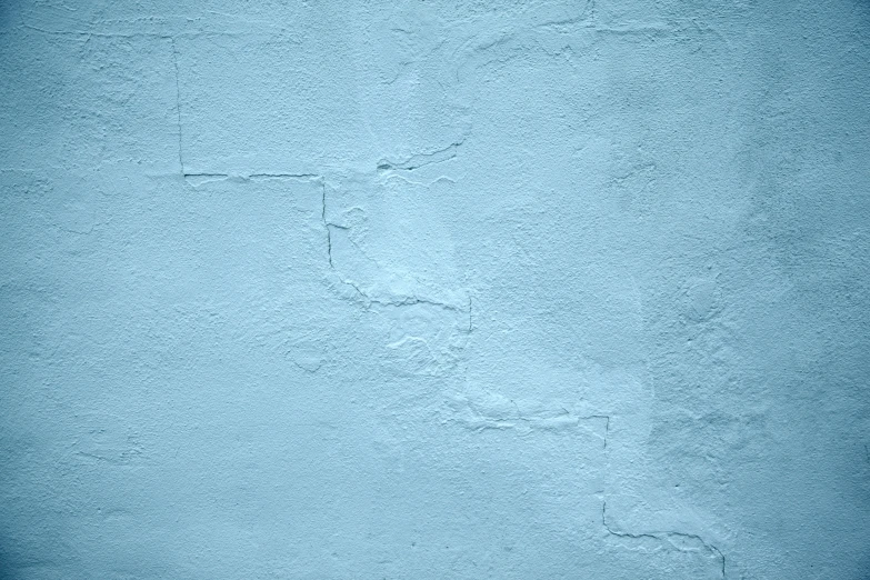 a close up of an old blue wall with some peeling paint