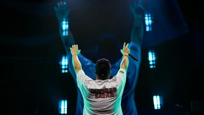 a man holding his arms up at the stage