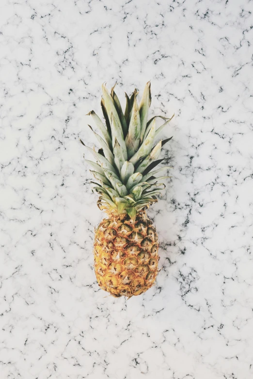 a pineapple with spots is sitting on a marble surface