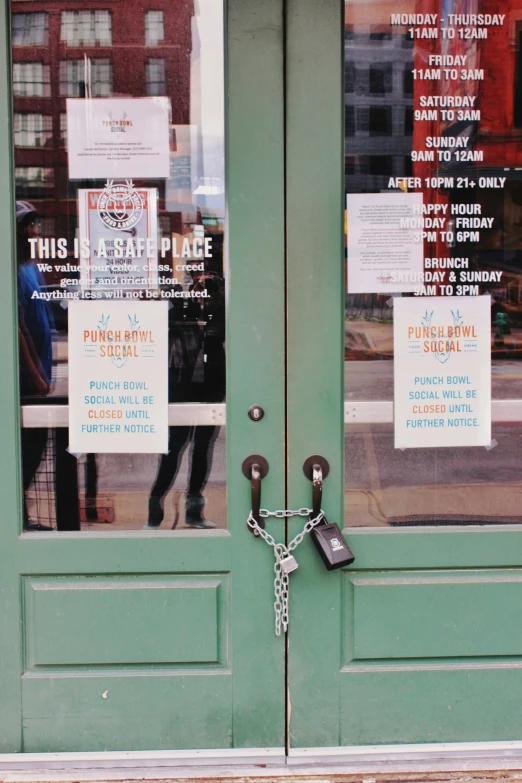 a green door with signs for restaurants and a chain attached to it