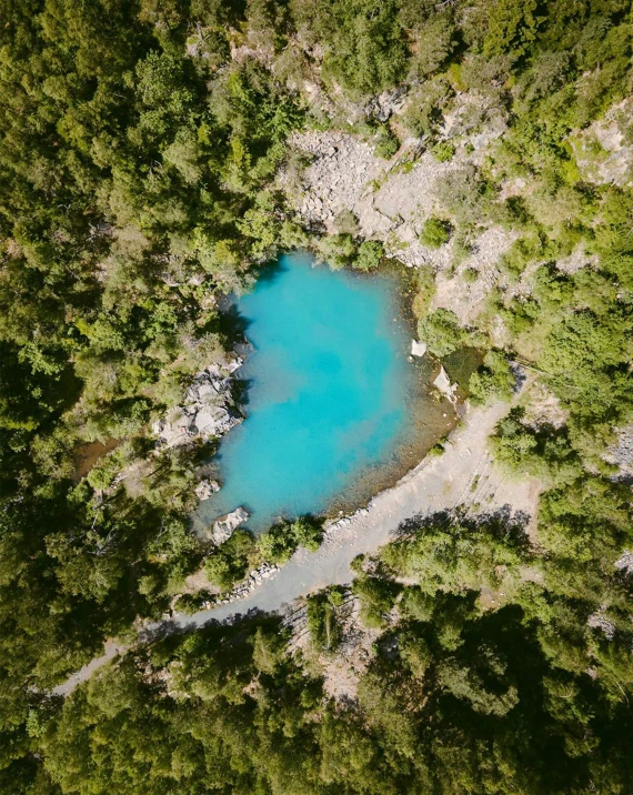 blue water surrounded by green trees and cliffs