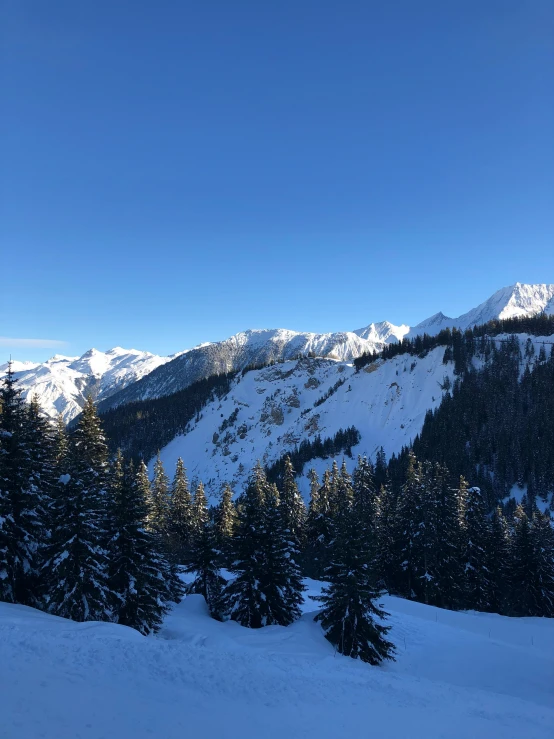 two people ski on the snow in a mountain range