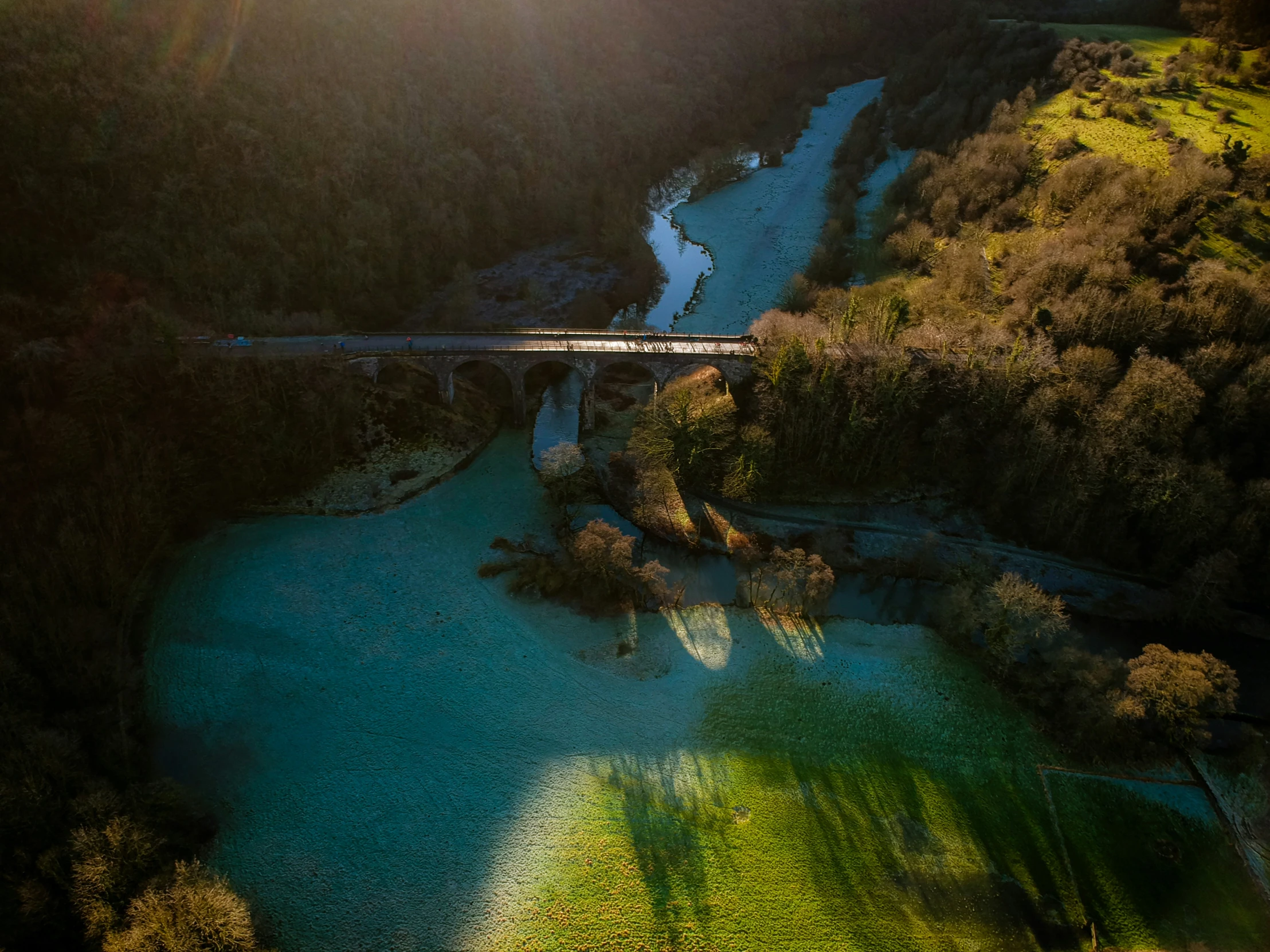 an aerial view of a river and road