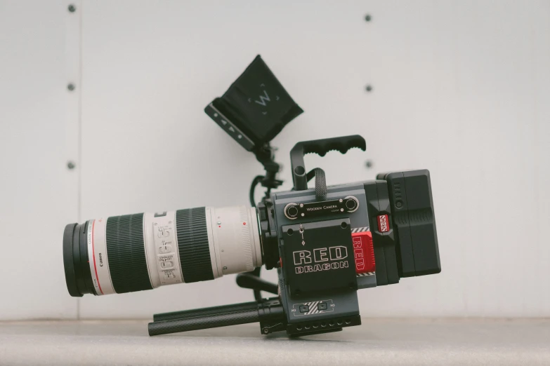 a video camera being filmed with a large lens on top of it