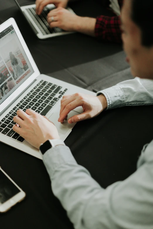 two people sitting in front of laptops on the couch