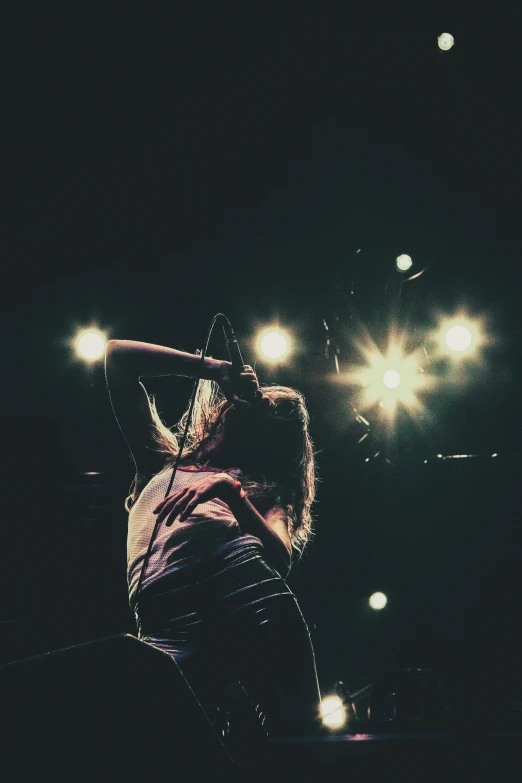 a man with microphone in his hand and lights behind him