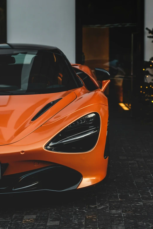 an orange sports car parked in front of a building