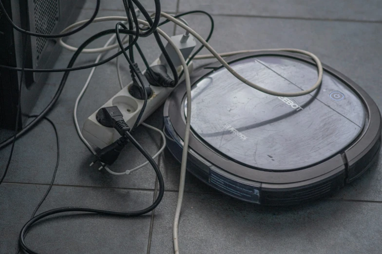 a wii mop laying on a tile floor next to wires and cords