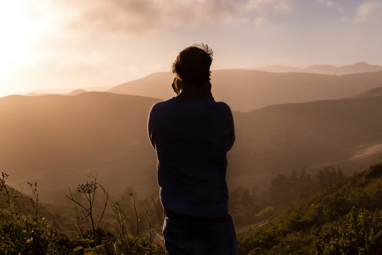 the man watches the mountain tops in the early evening sun