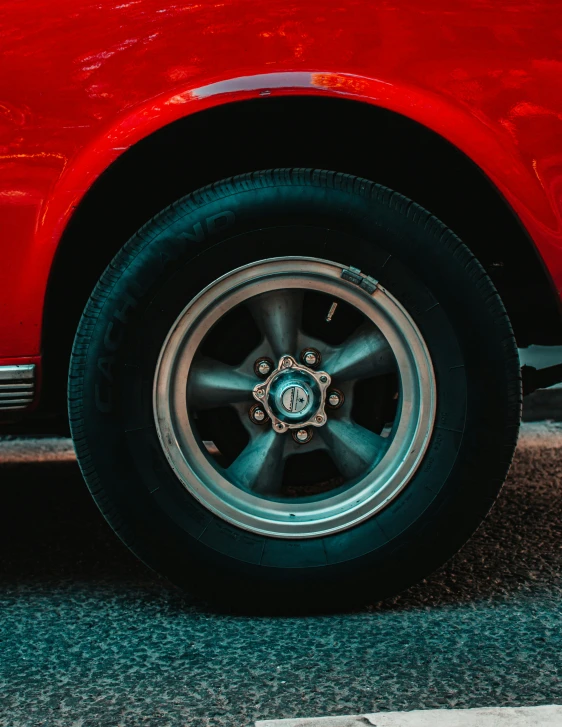 a close up view of the wheel of a red car