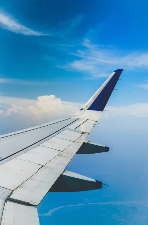 an airplane's wing flying over the ocean