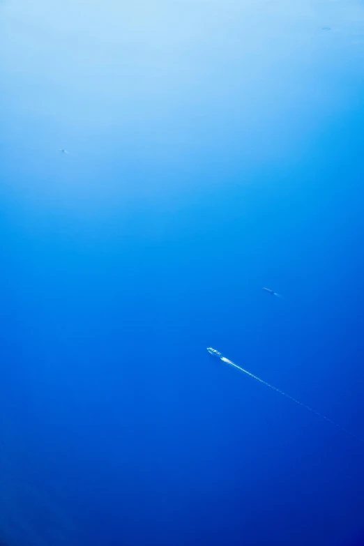 the bottom of the aircraft flying over a blue ocean