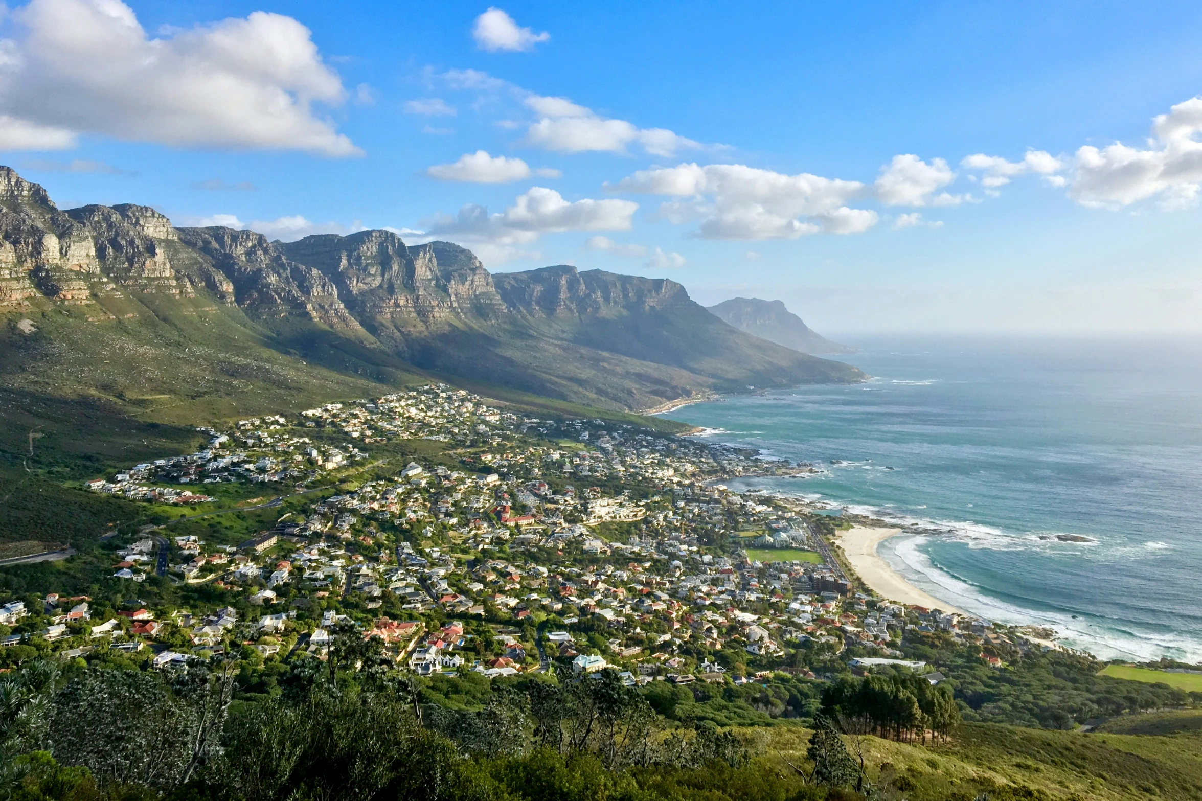 the view of a small town below the mountains