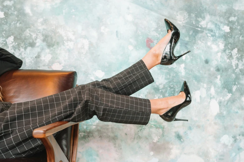 woman in black shoes sitting on a leather chair