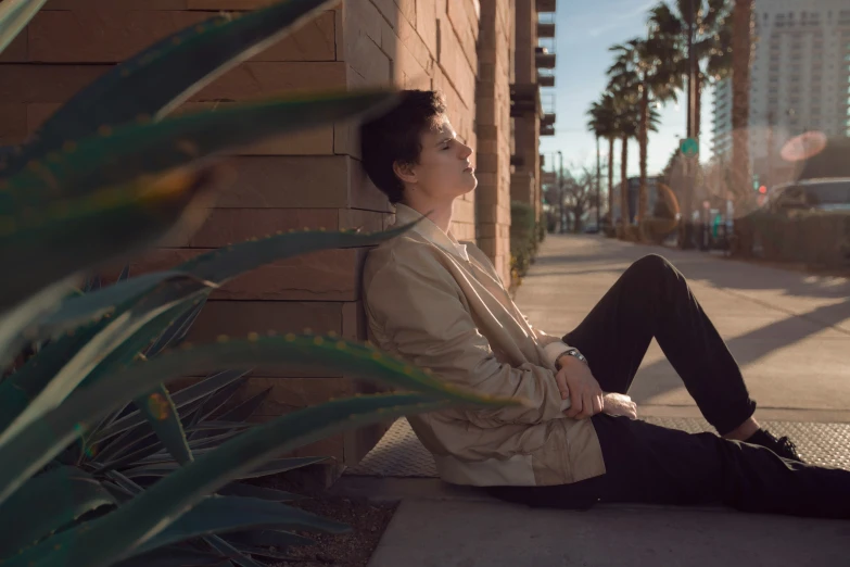 a person is sitting against a wall with their head down