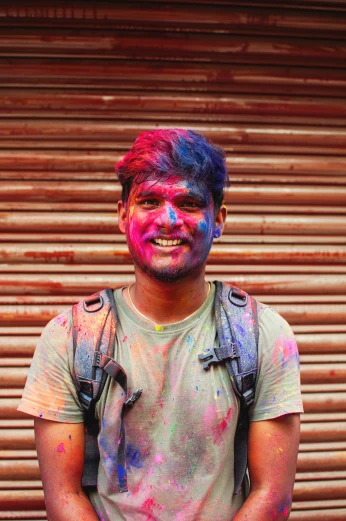 a young man smiles while wearing colorful clothing