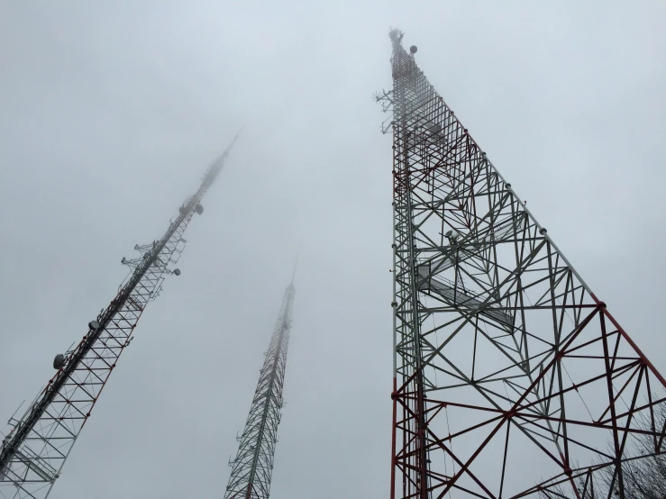 a tower with multiple antennas on top is standing in the mist