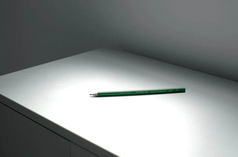 a pencil resting on the edge of an empty table