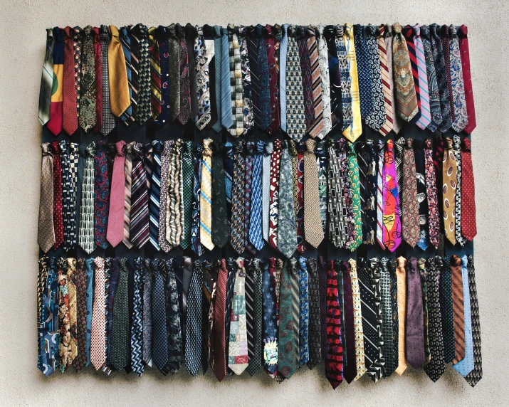 a large assortment of different types of ties hanging up