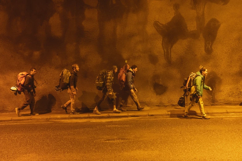 several people walking with backpacks in the street