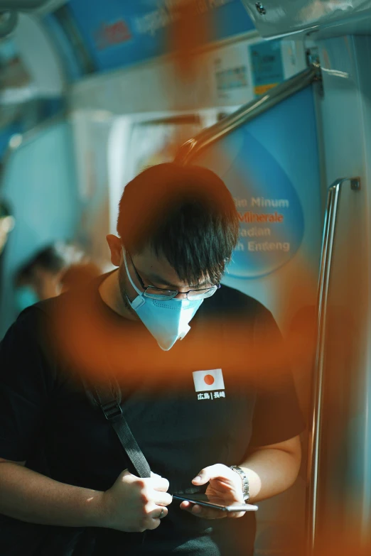 a man with a face mask on using a cellphone