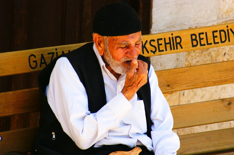 the old man is sitting on the bench