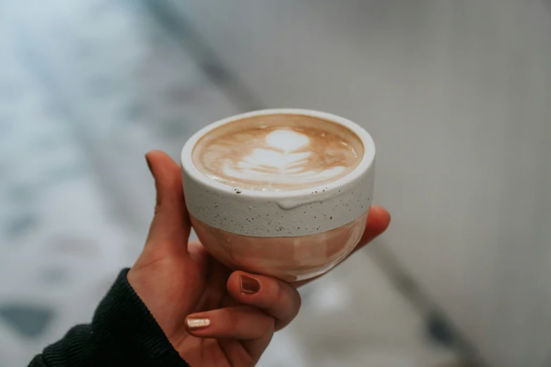 a person holds up a cup of coffee