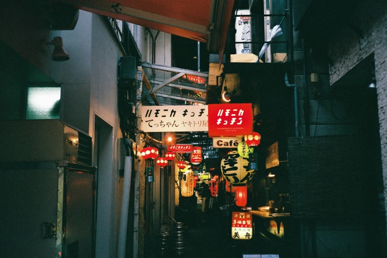 many signs at a narrow alley way in an asian city