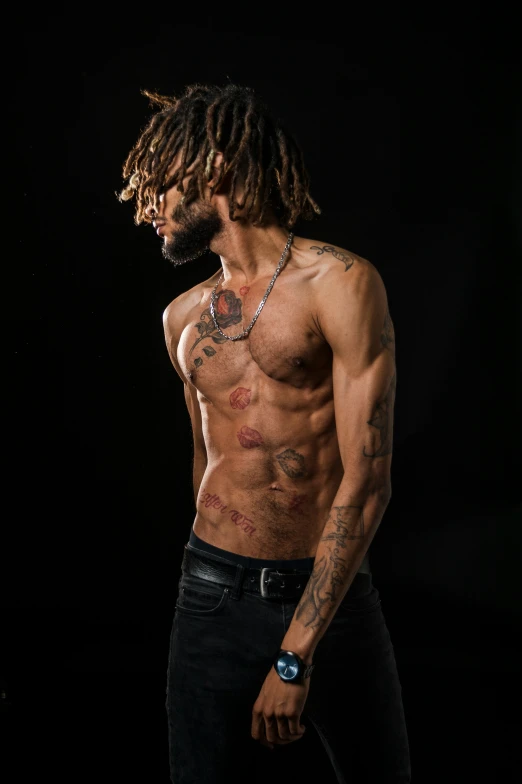 a shirtless man with dreadlocks and a black watch on his neck