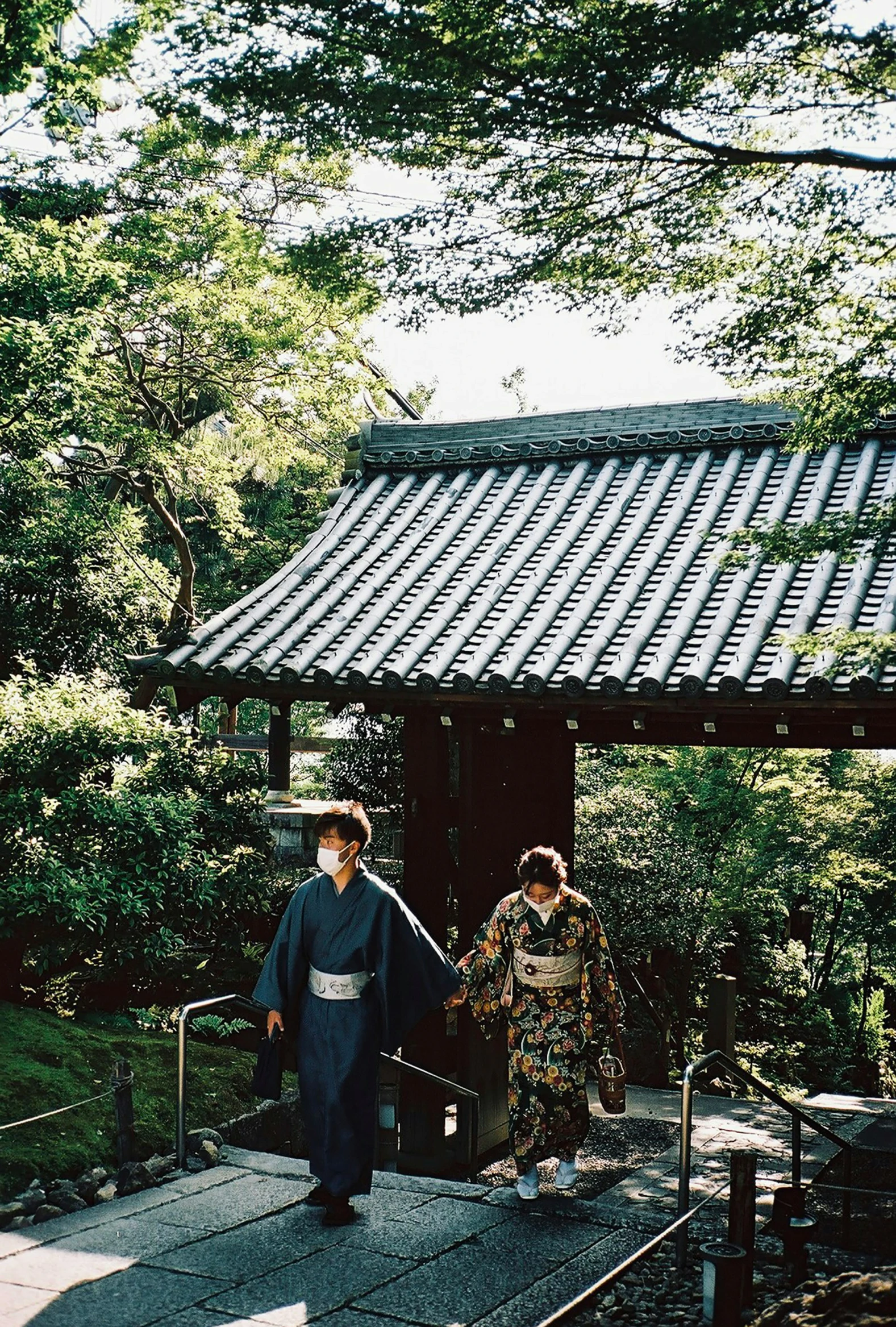 two men dressed in kimono standing near a small hut