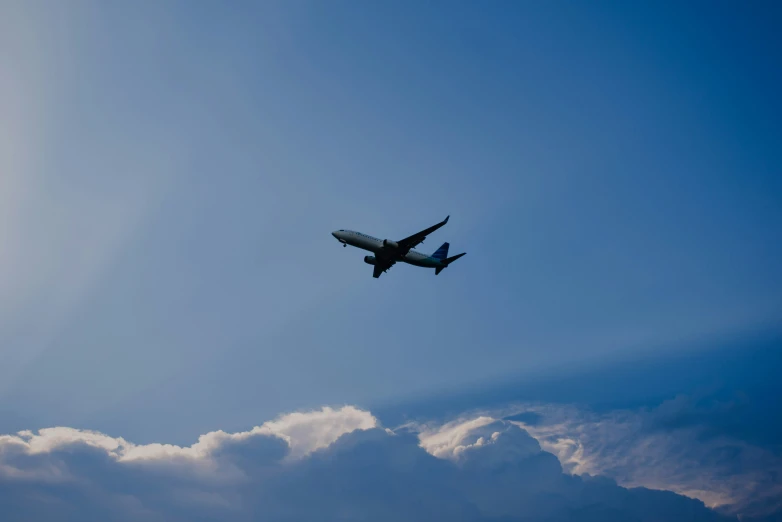 a blue and white jet is flying through the sky