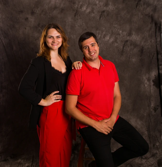 two people posing for a picture together in red shirts