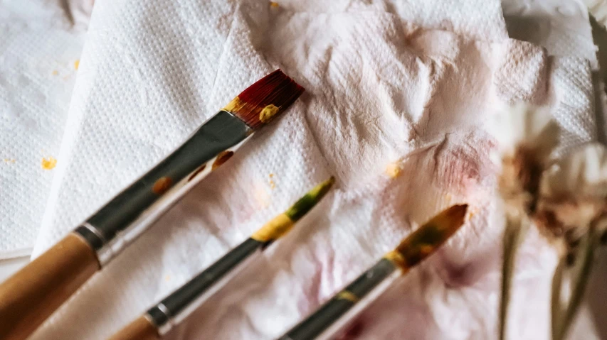 several brushes on paper towel with some flowers