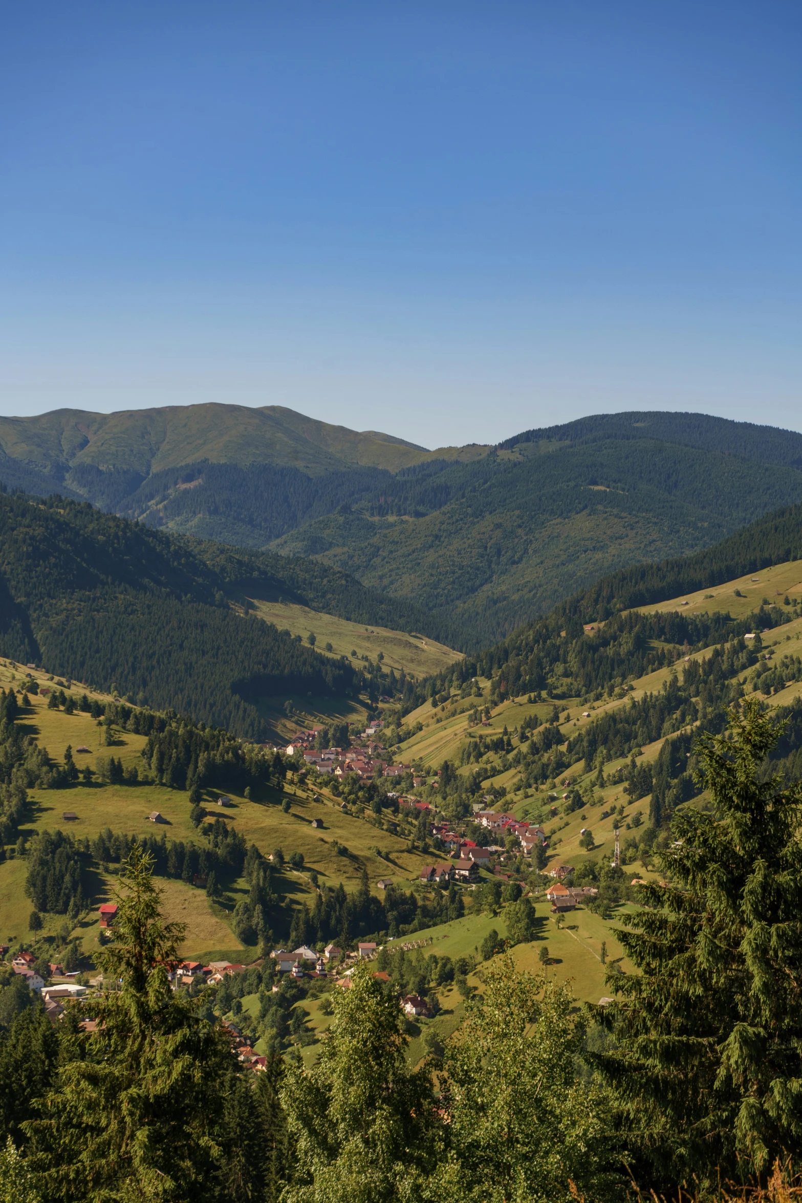 the valley with houses on it is surrounded by mountains