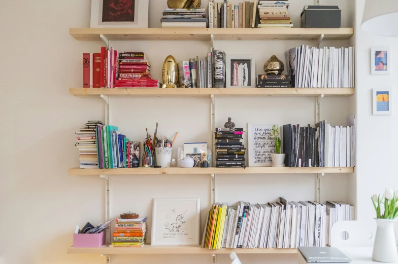 a bookshelf is organized with books, cards, and magazines