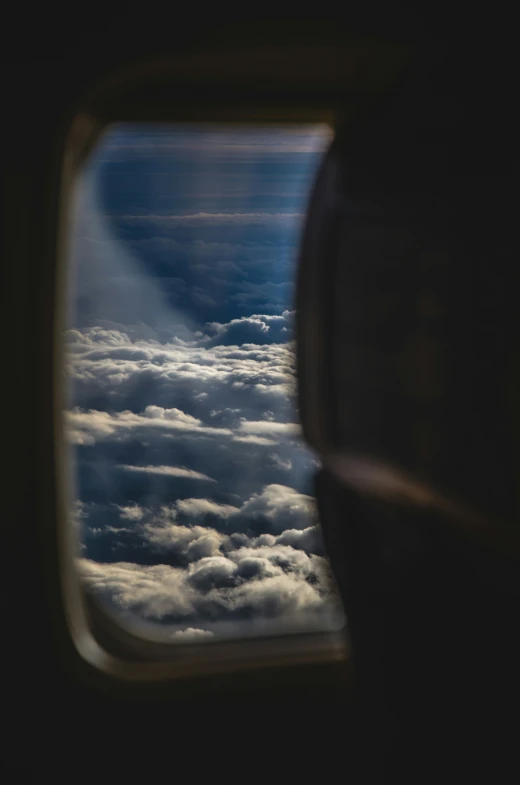 an airplane window flying through the clouds with the view looking through
