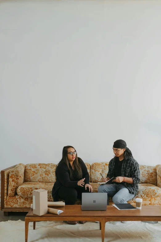 a couple sitting on top of a couch next to each other