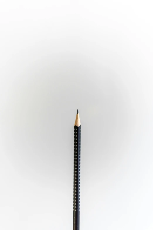 there is a black pencil sitting upright on the white surface