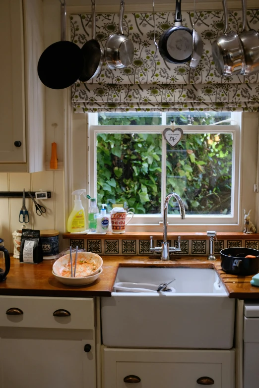 a sink is surrounded by pots and pans