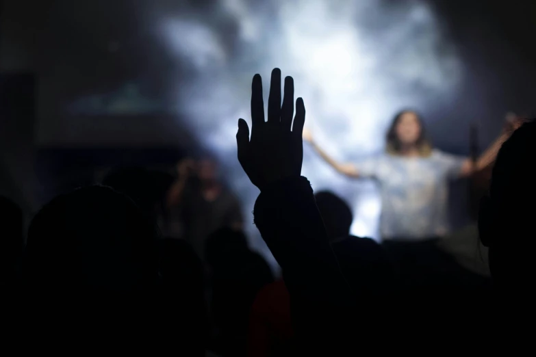 a woman standing in front of a crowd of people at night