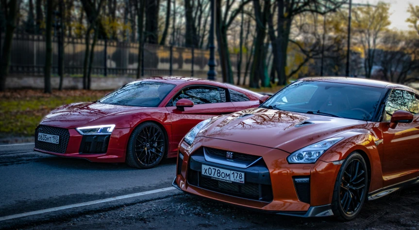 two red sports cars on the road next to each other