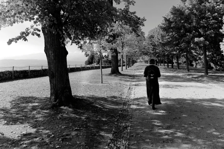 the man is walking with his back to the trees