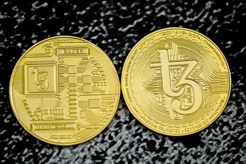 two gold bitcoins that are side by side