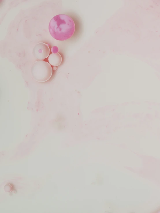 pink bubbles floating on the white surface of a surface