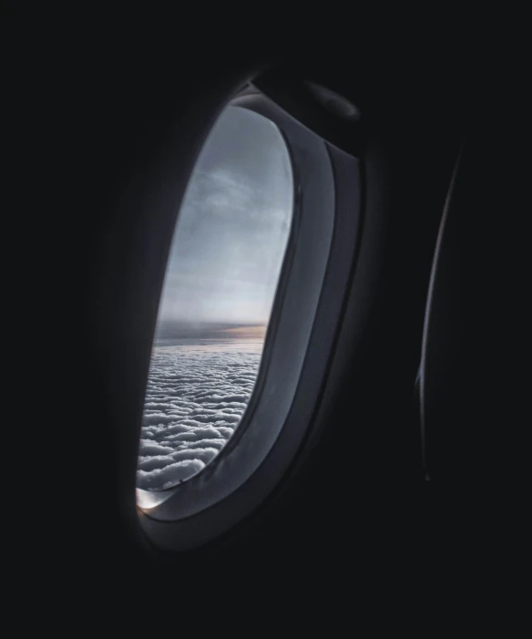 the window of an airplane with the view of clouds outside