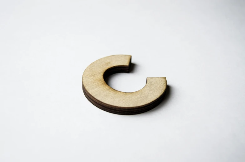 a wooden letter is sitting on a white surface