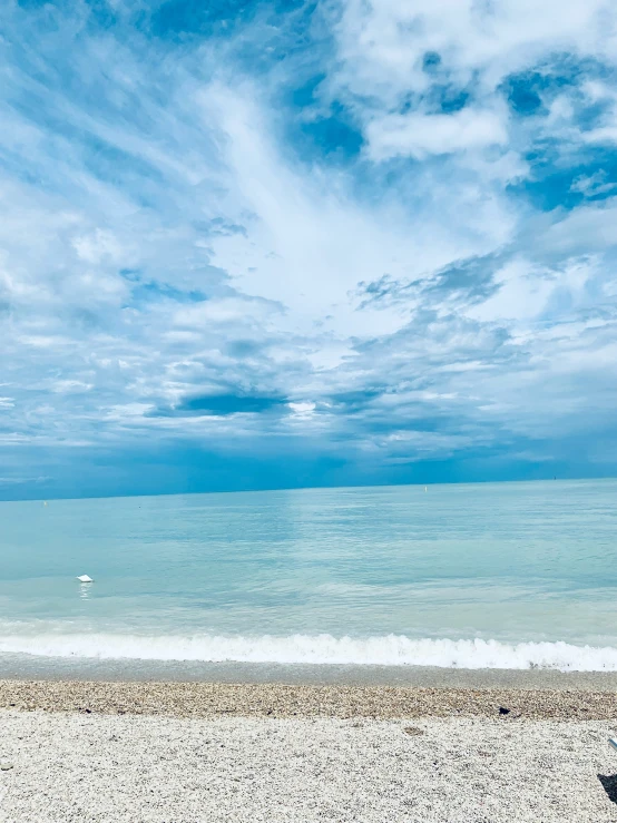 a man stands on the beach next to a boat in the ocean