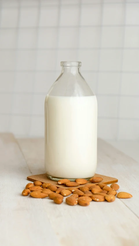 a bottle of milk is sitting on a table with some peanuts