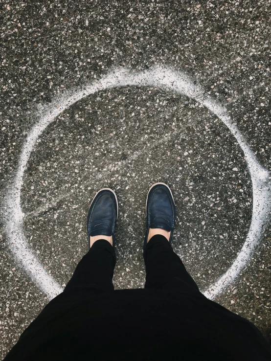 a person standing on asphalt with one foot in the air