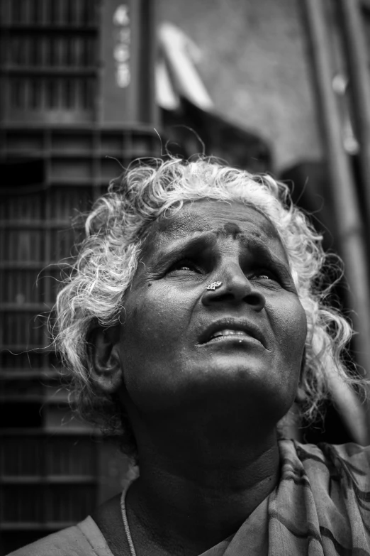 a woman wearing a necklace looking up with eyes closed